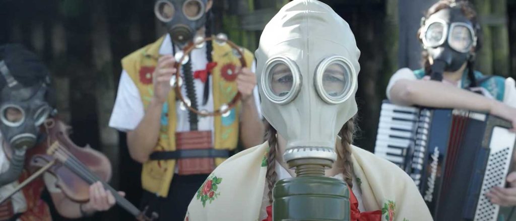 a group of musicians wearing gas masks