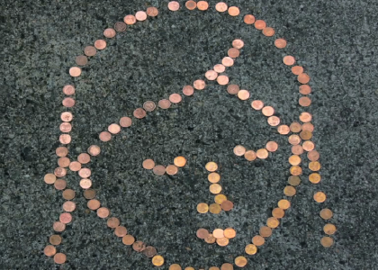 pennies on the ground make the outline of a persons head