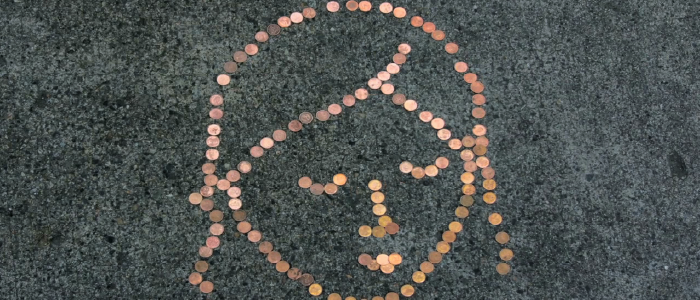 pennies on the ground make the outline of a persons head