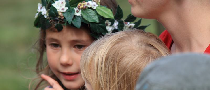 closeup of a young child wearing a headband of leaves