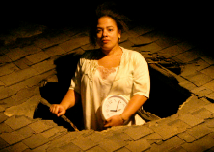 an actor pokes thru a hole in a roof