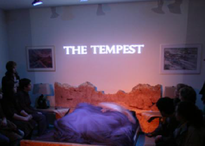 "The Tempest" projected on a wall surounded by audience members
