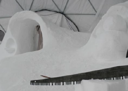 a crosscut saw in a block of snow inside a dome