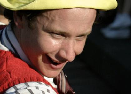 closeup of an actor with yellow hat and red vest