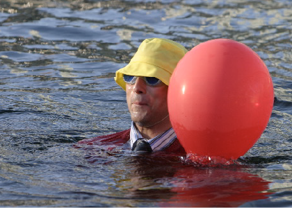 actor in the ocean with yellow hat and red ballon