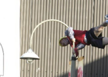 actor doing a flag pole on a lamp pole
