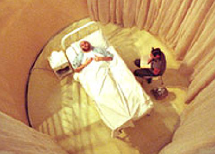 aerial view of a man in a bed surounded by curtains