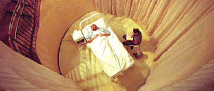 aerial view of a man in a bed surounded by curtains