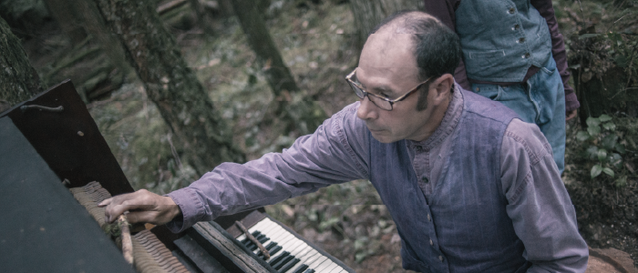 a person playing the piano in the forest