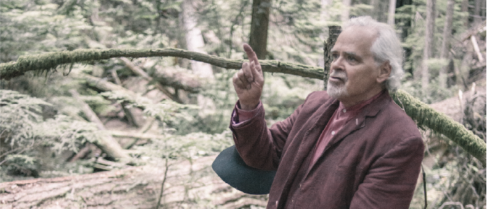 an actor in the forest pointing