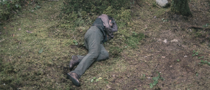 a person laying on the forest floor