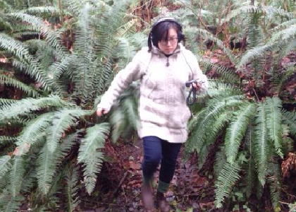 a women running through big ferns listening to the nature around her