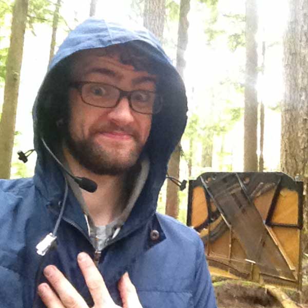 a man wearing a radio in front of a piano in the forest